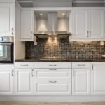 Classic white kitchen cabinets with raised panel doors and black countertops