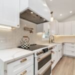 Custom wood range hood above kitchen stove with white cabinetry