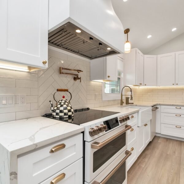 Custom wood range hood above kitchen stove with white cabinetry