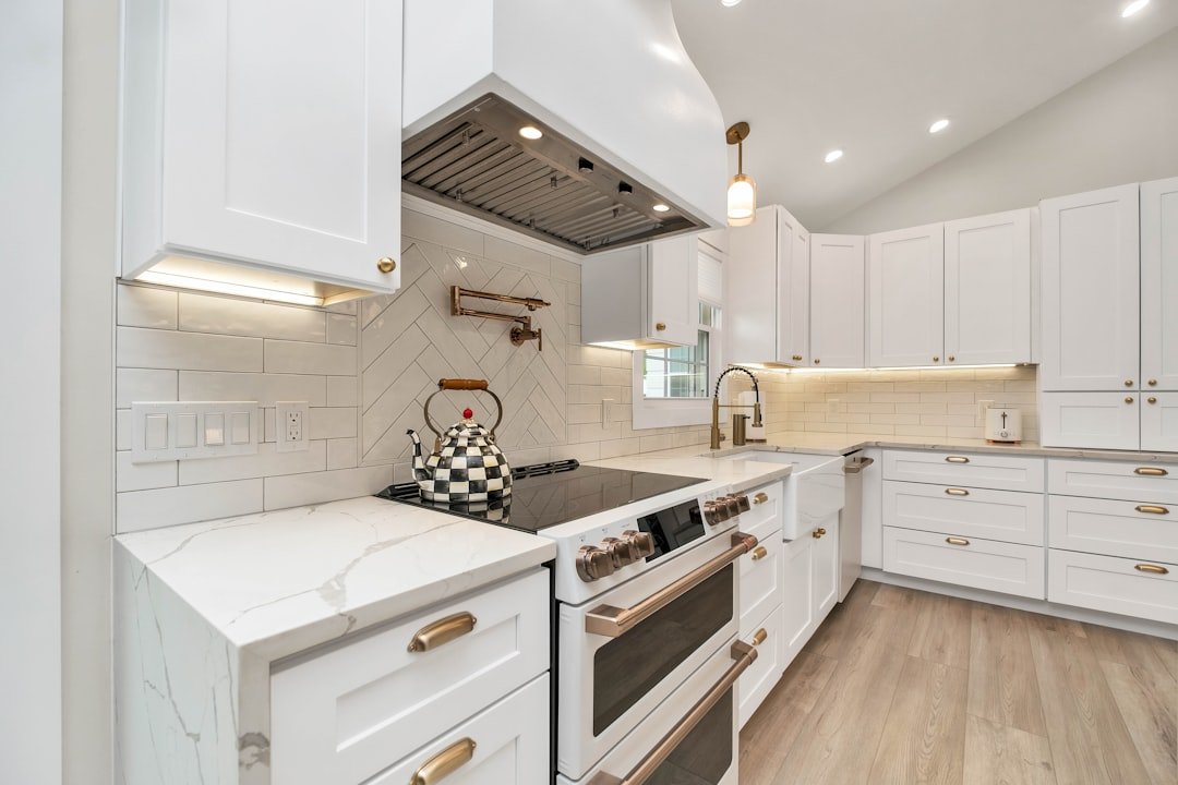 Custom wood range hood above kitchen stove with white cabinetry