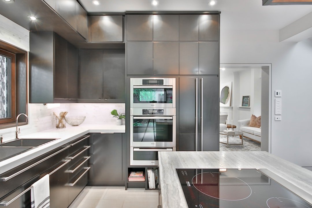 Shaker gray kitchen cabinets with modern stainless steel appliances and marble countertops